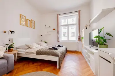 a white living room with a bed and a window at Premium Apartment Nearby Centre in Prague