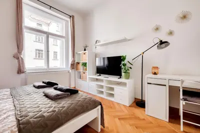 a bedroom with a bed and a tv and a window at Premium Apartment Nearby Centre in Prague