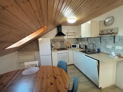 a kitchen with a wooden table and a wooden ceiling at Apartmán Svaté Pole in Svaté Pole