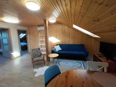 a living room with a blue couch and a wooden ceiling at Apartmán Svaté Pole in Svaté Pole