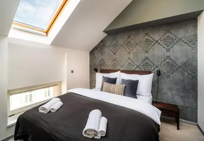 a bedroom with a large bed with towels on it at AC Luxury Loft Friends & Family Edition in Prague