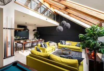 a living room with yellow couches and a pool table at AC Luxury Loft Friends & Family Edition in Prague