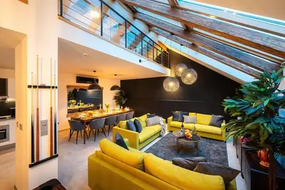 a living room with yellow couches and a dining room at AC Luxury Loft Friends & Family Edition in Prague