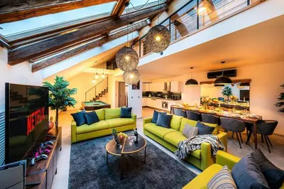 a living room with yellow couches and a kitchen at AC Luxury Loft Friends & Family Edition in Prague