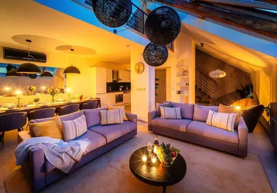 a living room with a purple couch and a kitchen at AC Old Town Grand Luxury&Family Loft in Prague