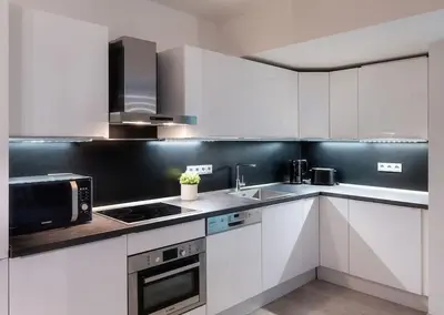 a kitchen with white cabinets and a microwave at AC Old Town Grand Luxury&Family Loft in Prague