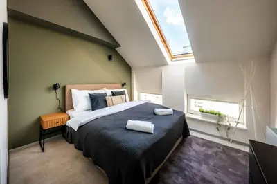 a bedroom with a large bed with two towels on it at AC Old Town Grand Luxury&Family Loft in Prague