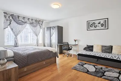 a bedroom with a bed and a desk and a window at Apartment Sun & Moon in Prague