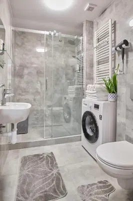 a bathroom with a shower toilet and a washing machine at Apartment Sun & Moon in Prague