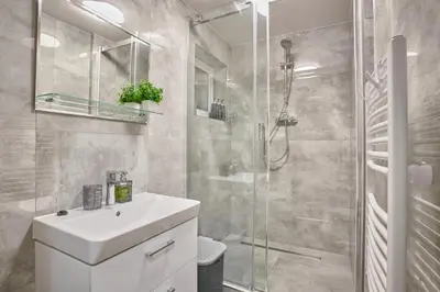 a bathroom with a white sink and a shower at Apartment Sun & Moon in Prague