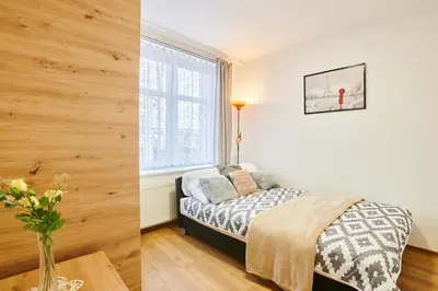 a bedroom with a bed and a vase of flowers on a table at Apartment Sun & Moon in Prague
