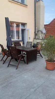 a wooden table and chairs on a patio at Anenska by Charles Bridge 3 in Prague