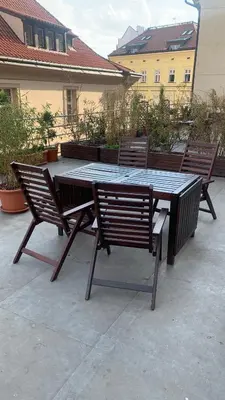 a picnic table with two chairs around it on a patio at Anenska by Charles Bridge 3 in Prague