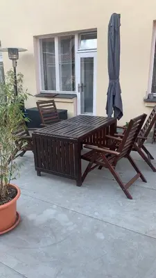 a wooden table and two chairs and an umbrella at Anenska by Charles Bridge 3 in Prague