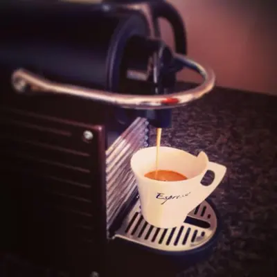 a cup of coffee is being brewed in a coffee machine at Cozy apartment fully equipped in Prague