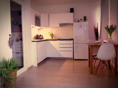 a kitchen with a table and a white refrigerator at Cozy apartment fully equipped in Prague