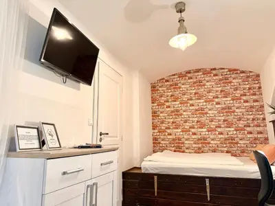 a small bedroom with a brick wall and a bed at Urban downtown studio in Prague