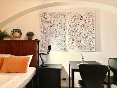 a bedroom with a bed with a desk and a table with chairs at Urban downtown studio in Prague