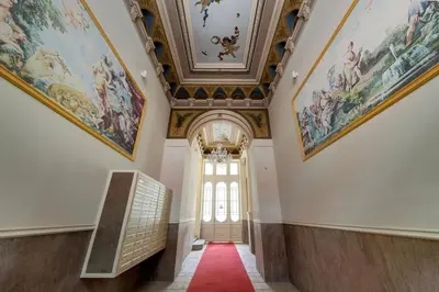 a hallway with paintings on the ceilings and a door at Urban downtown studio in Prague