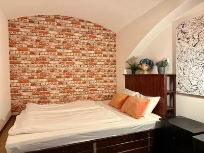 a bed in a room with a brick wall at Urban downtown studio in Prague