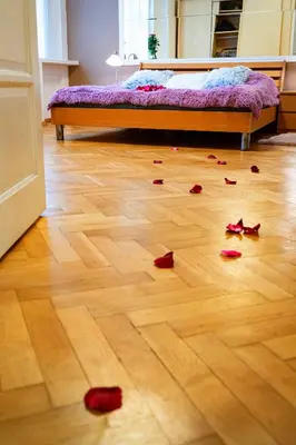 a bedroom with a bed and a wooden floor with roses on the floor at Moonlight Deluxe Suite in Prague