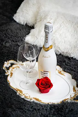 a bottle of wine and a glass and a rose at Moonlight Deluxe Suite in Prague
