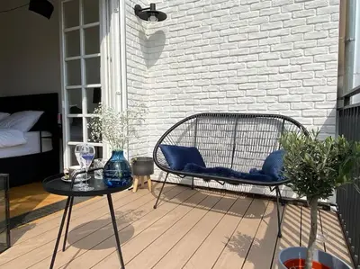 a patio with chairs and a table and a bed at Romantic Terrace Studio in Karlín in Prague