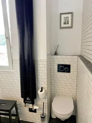 a white bathroom with a toilet and a window at Romantic Terrace Studio in Karlín in Prague