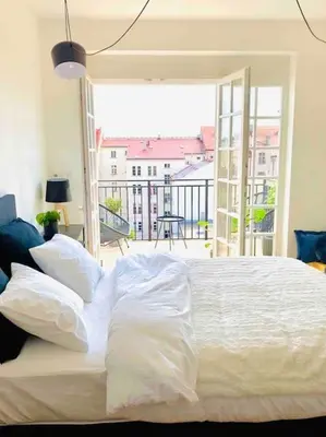 a white bed in a bedroom with a balcony at Romantic Terrace Studio in Karlín in Prague