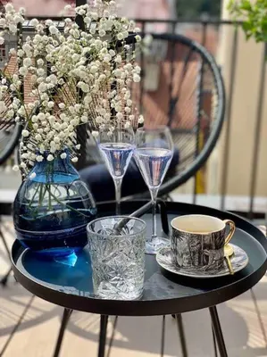 a table with a blue vase and glasses on it at Romantic Terrace Studio in Karlín in Prague