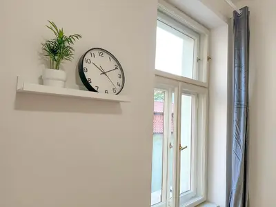 a clock on a wall next to a window at Stylish Apartment Next To Wenceslas Square in Prague