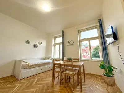 a bedroom with a bed and a table and chairs at Stylish Apartment Next To Wenceslas Square in Prague