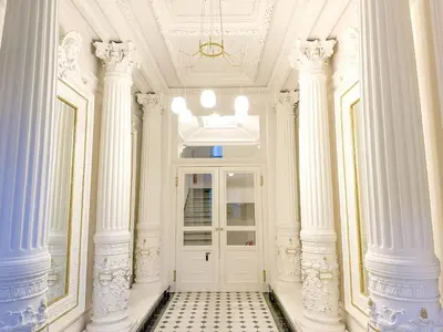 a hallway with white columns and a white door at Stylish Apartment Next To Wenceslas Square in Prague