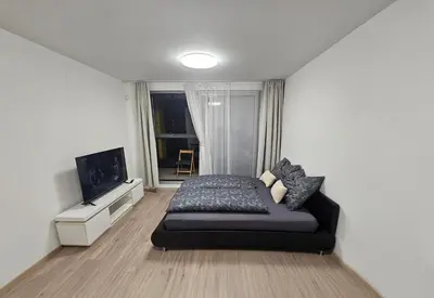 a bedroom with a bed and a flat screen tv at Apartment - O2 Arena Prague with parking in Prague