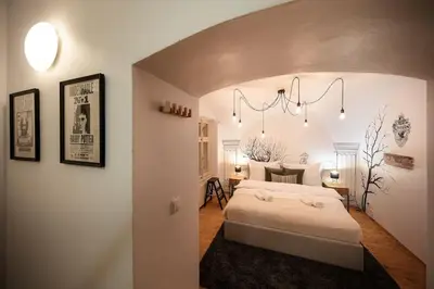 a bedroom with a white bed and a chandelier at 4BR & 2,5Bath Harry Potter Old TOWN and GREAT patio in Prague