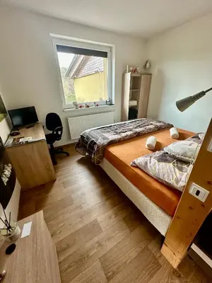 a bedroom with a bed and a desk and a window at Dolpo 5 in Benešov