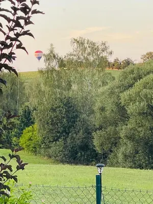 a hot air balloon flying over a field with a fence at Dolpo 5 in Benešov