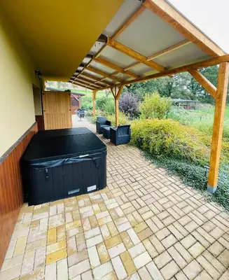 a patio with a hot tub under a pergola at Dolpo 5 in Benešov