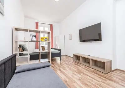 a living room with a television and a couch at Elegance Apartments in Prague