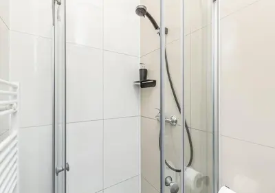 a shower with a shower head in a bathroom at Elegance Apartments in Prague