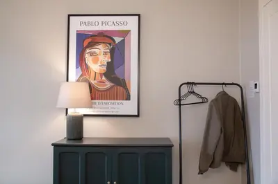 a painting of a woman on a wall next to a lamp at Charming Apartment by Wenceslas square and National Museum with AC in Prague