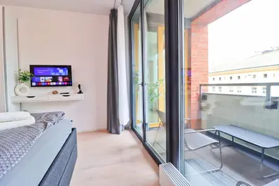 a living room with a couch and a tv and a window at The Peony Apartment in Smichov, Prague 5 in Prague