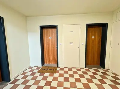 a room with three doors and a checkered floor at The Peony Apartment in Smichov, Prague 5 in Prague