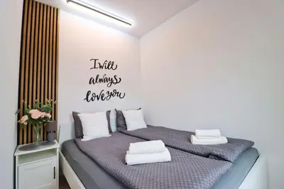two twin beds in a white room with words on the wall at The Peony Apartment in Smichov, Prague 5 in Prague