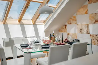 a dining room with a glass table and white chairs at City View Luxury Apartments with Foosball & Xbox - In City Centre in Prague