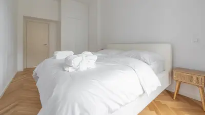 a white bed with white sheets and pillows on it at Apartment in the Clouds Letná - Luxury with Romantic Balconies in Quiet Centre of Prague in Prague