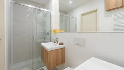 a white bathroom with a sink and a shower at Apartment in the Clouds Letná - Luxury with Romantic Balconies in Quiet Centre of Prague in Prague
