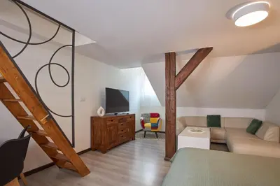 a living room with a couch and a tv at Rybna - Old Town Residence in Prague