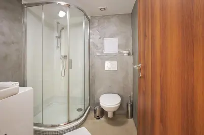 a bathroom with a toilet and a glass shower at Rybna - Old Town Residence in Prague