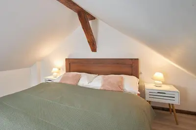 a bedroom with a green bed and two lamps at Rybna - Old Town Residence in Prague